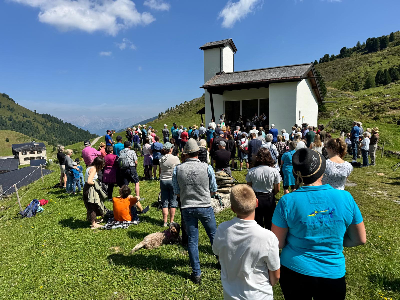 Almerermesse beim Soldatenkirchlein in der Lizum: zahlreiche Besucherinnen und Besucher versammeln sich bei Sonnenschein vor der Kapelle.