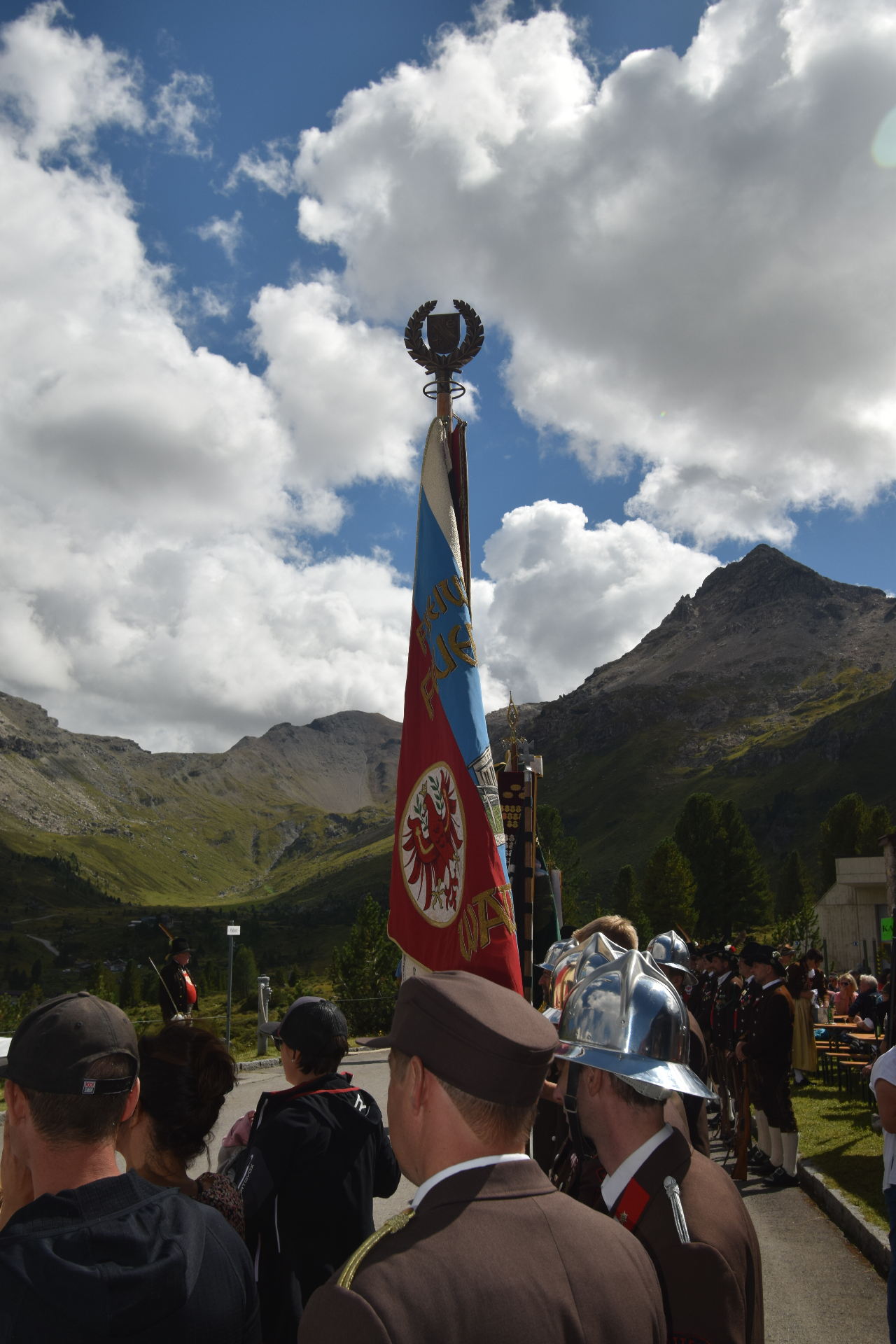 Fahnenabordnung der Freiwilligen Feuerwehr bei der Mölsbergmesse vor der Bergkulisse des Wattentals