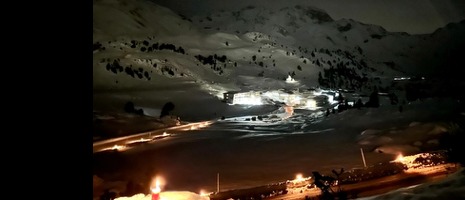 Nächtliche Winterlandschaft mit leuchtenden Herz-Jesu-Feuern und Bergsilhouetten unter Sternenhimmel im Wattental.