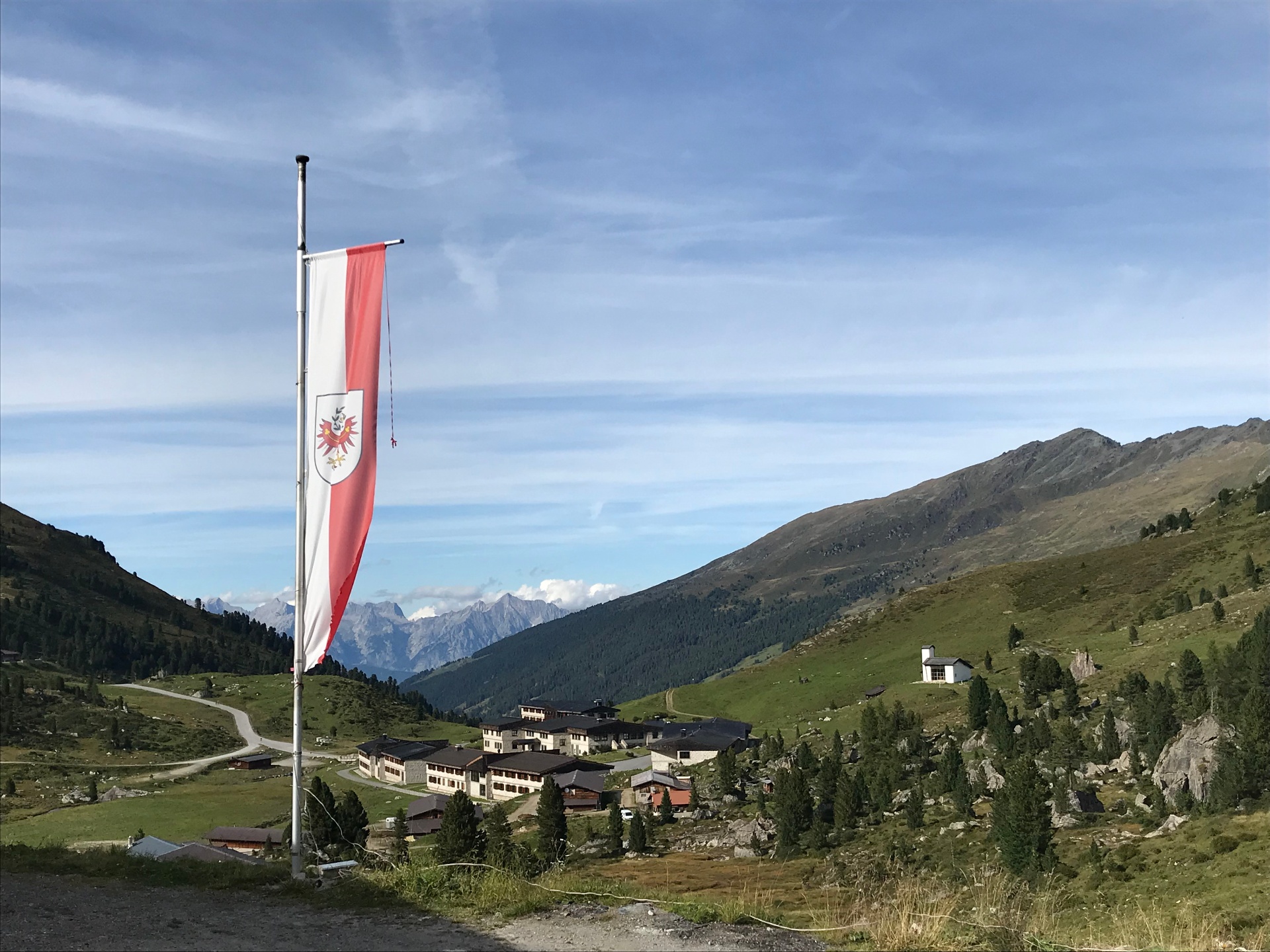 Lizum im Wattental – Tiroler Fahne vor Bergkulisse, Almhäusern und Alpenpanorama